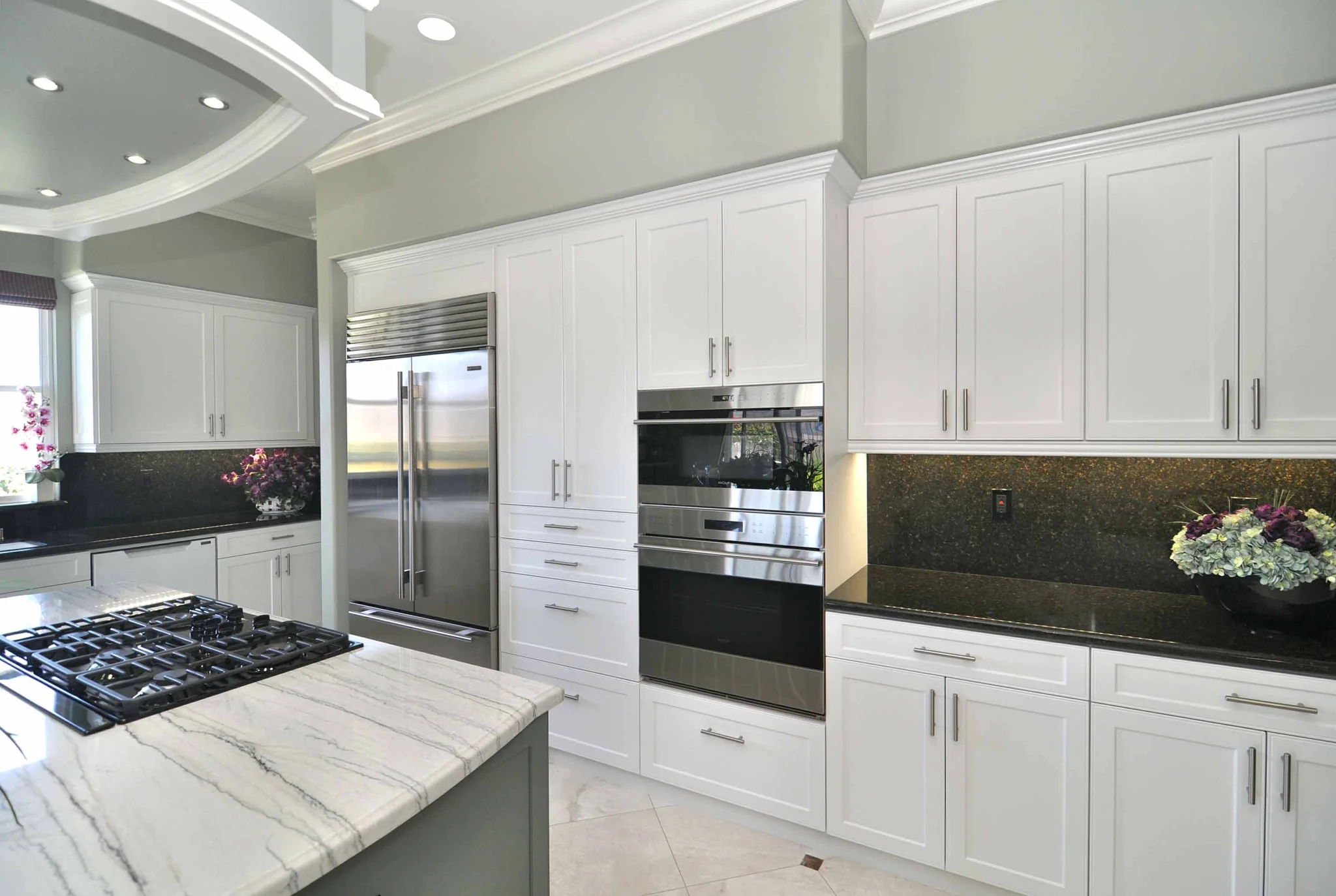 Luxury custom kitchen cabinetry with walk-in pantry wall and quartz island