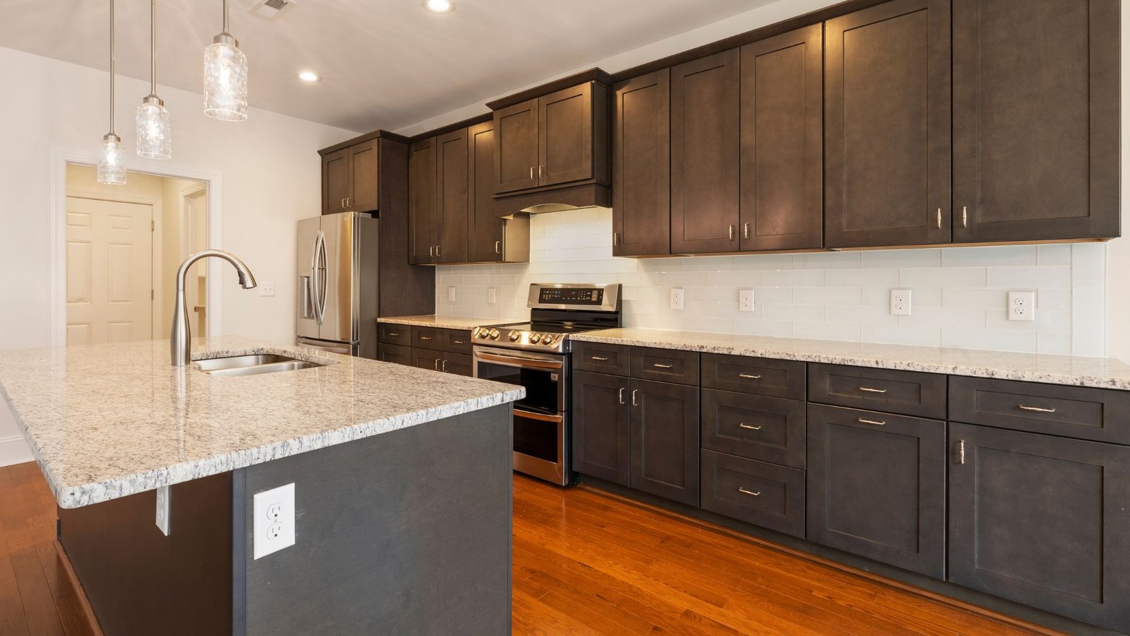 Executive custom kitchen cabinetry and quartz waterfall island installed by Grace Cabinets